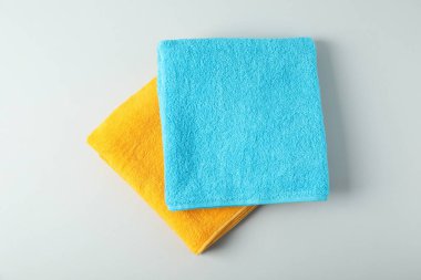 Bright terry towels on light grey background, top view