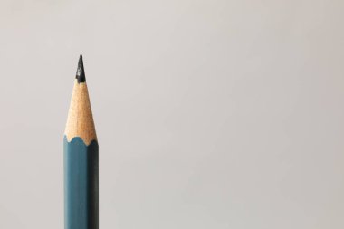 Gri arka planda keskin bir grafit kalem, yakın plan. Metin için boşluk