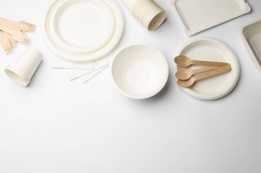 Beyaz arka planda tek kullanımlık sofra takımı ve peçeteler, düz konum