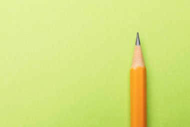 Açık yeşil zemin üzerinde keskin bir grafit kalem, üst görüş. Metin için boşluk