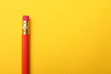 Sarı arka planda bir grafit kalem, en üstte. Metin için boşluk