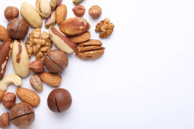 Beyaz arka planda farklı fındıkların karışımı, düz yatış. Metin için boşluk