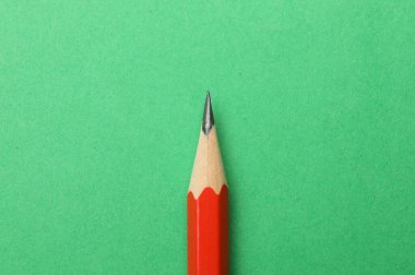 Yeşil arka planda keskin bir grafit kalem, üst görünüm