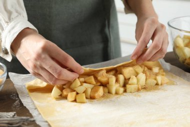 Mutfaktaki masada lezzetli elmalı turta yapan kadın, yakın plan.