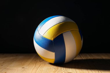 Ahşap zemin üzerinde bir voleybol topu siyah zemin karşısında