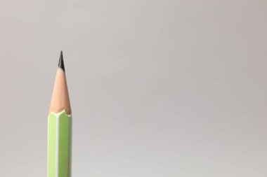 Gri arka planda keskin bir grafit kalem, yakın plan. Metin için boşluk