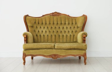 Beyaz duvarın yanındaki şık kanepe.