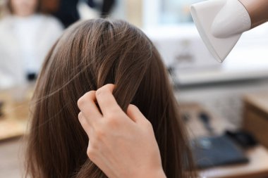 Kuaför kuaför kuaförde müşterinin saçını kurutuyor.