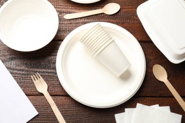 Tek kullanımlık sofra takımı ve peçeteler ahşap masada, düz yatıyordu.