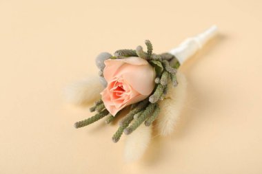 Boutonniere with beautiful flowers on beige background, closeup