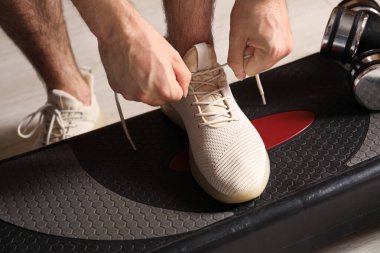 Ayakkabı bağcığını bağlayan adam içeride, yakın plan.