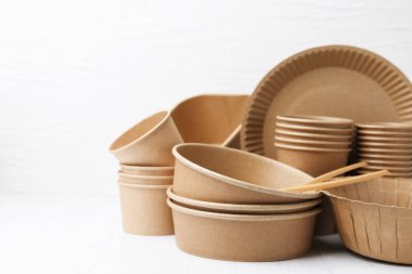 Set of disposable tableware on white table, closeup. Space for text