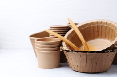 Set of disposable tableware on white table, closeup. Space for text