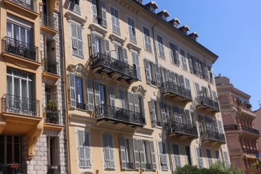 Beautiful building with windows and balconies against blue sky in city