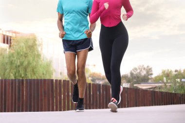 Spor giyimli bir çift dışarı koşuyor, yakın plan. Sağlıklı yaşam tarzı