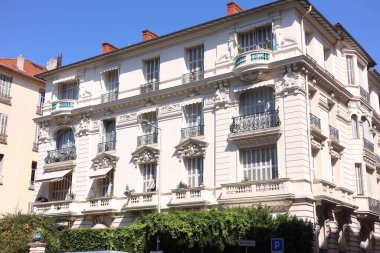 Beautiful building with windows and balconies against blue sky in city
