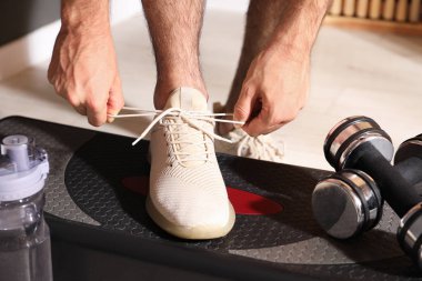 Ayakkabı bağcığını bağlayan adam içeride, yakın plan.