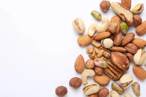 Beyaz arka planda farklı fındıkların karışımı, düz yatış. Metin için boşluk
