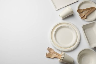 Set of disposable tableware on white background, flat lay. Space for text