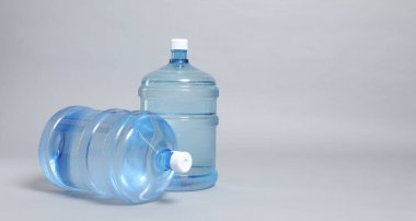 Açık gri arka planda su bulunan soğutucu şişeler, yakın plan. Metin için boşluk