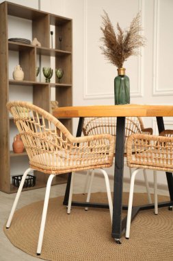 Yemek odasında dekor ve şık sandalyeli ahşap masa.