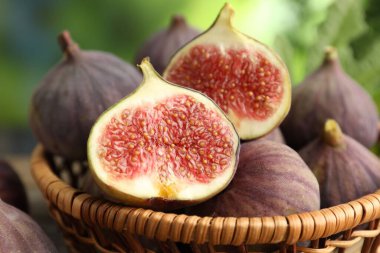 Hasır sepette taze incir, bulanık arka planda, yakın plan.