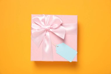 Turuncu arka planda boş etiketli hediye kutusu, üst görünüm