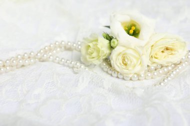 Beautiful flowers and pearls on lace fabric, closeup