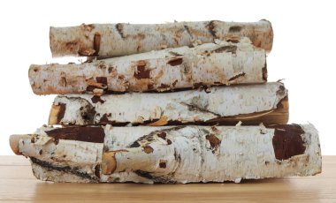 Ahşap masa üzerine kesilmiş odun yığını beyaz arka plana karşı