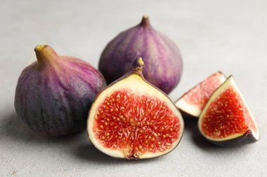 Gri desenli masadaki incirlerin tamamı ve kesimi yakın plan.