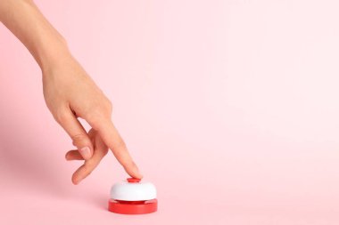 Pembe arka planda kırmızı düğmeye basan kadın, yakın plan. Metin için boşluk