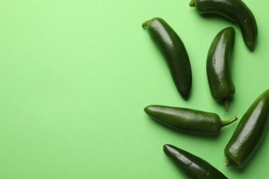 Açık yeşil zemin üzerinde olgun jalapeno biberleri, düz yatıyordu. Metin için boşluk