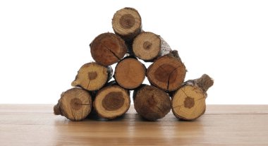 Ahşap masa üzerine kesilmiş odun yığını beyaz arka plana karşı