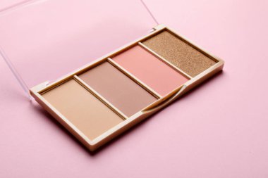 Beautiful contouring palette on light pink background, closeup