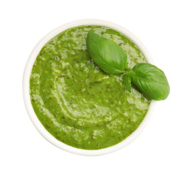 Pesto sauce with basil leaves in bowl isolated on white, top view