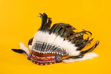 Traditional warbonnet (Native American chief headdress) on yellow background