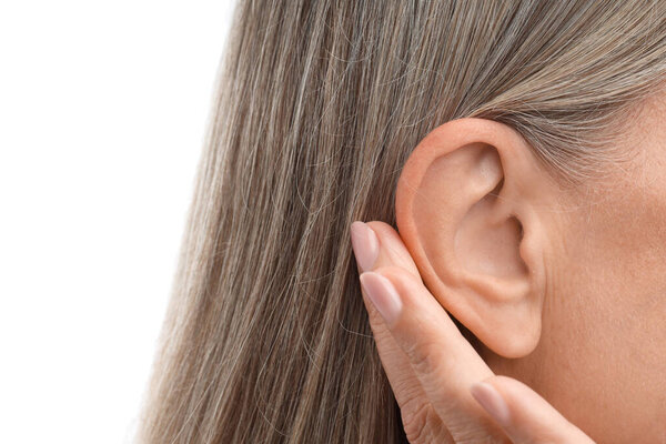 Звук. Старшая женщина показывает руку к уху жест на белом фоне, крупным планом