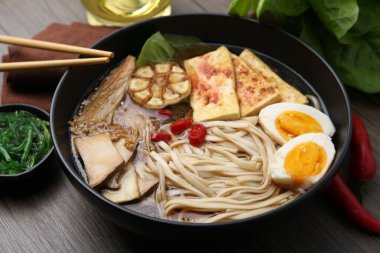 Ahşap masadaki mantarlı, Enoki ve Kral istiridyeli lezzetli ramen.
