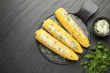 Siyah masada maydanozlu ve peynirli mısır koçanlarının tadı açık.