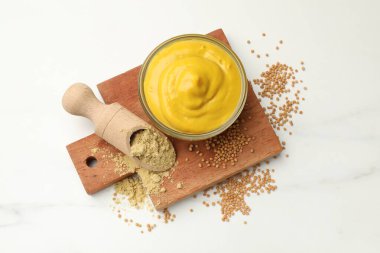 Different types of mustard on white marble table, top view