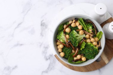 Shimeji mantarlı lezzetli salata, nohut ve brokoli kasede beyaz mermer masada, üst manzara. Metin için boşluk