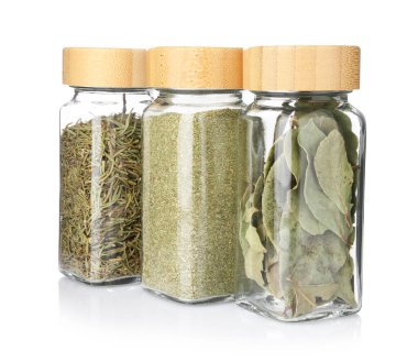 Beyaz kavanozlardaki farklı aromatik baharatlar.