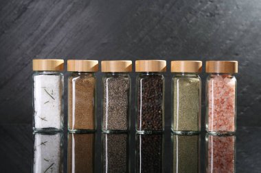 Ayna yüzeyinde cam kavanozlardaki farklı baharatlar.