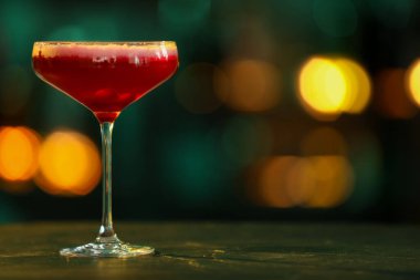 Arka planda bulanık duran bir bardak alkollü kokteyl. Metin için boşluk