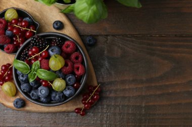 Farklı olgun meyveler ve fesleğenler ahşap masada, düz yerde. Metin için boşluk