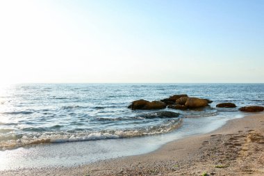 Güzel dalgalı deniz, taşlar ve kumlu sahil