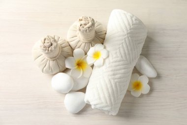 Beautiful spa composition with herbal bags on white wooden table, flat lay