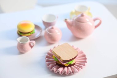 Tea set on white table indoors, closeup. Child's toy