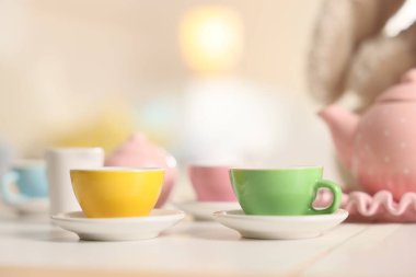 Tea set on white table indoors, closeup with space for text. Child's toy