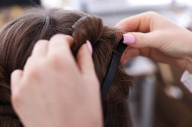 Profesyonel kuaför müşteriyle kuaförde çalışıyor.